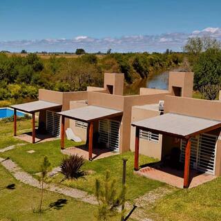 Vista aérea de los loft, la pileta y el río Carcarañá