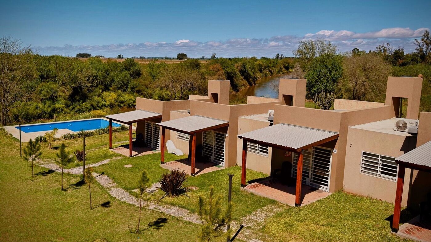 Vista aérea de los loft, la pileta y el río Carcarañá